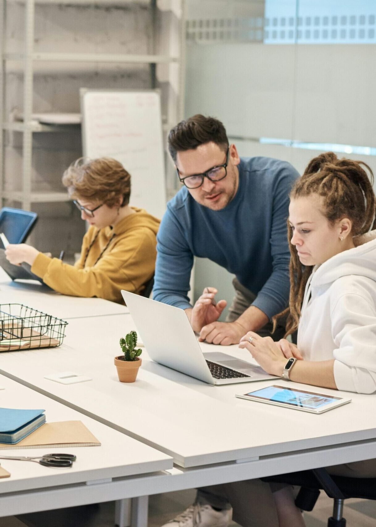 Team collaboration in a modern office setting with computers and diverse employees working together.